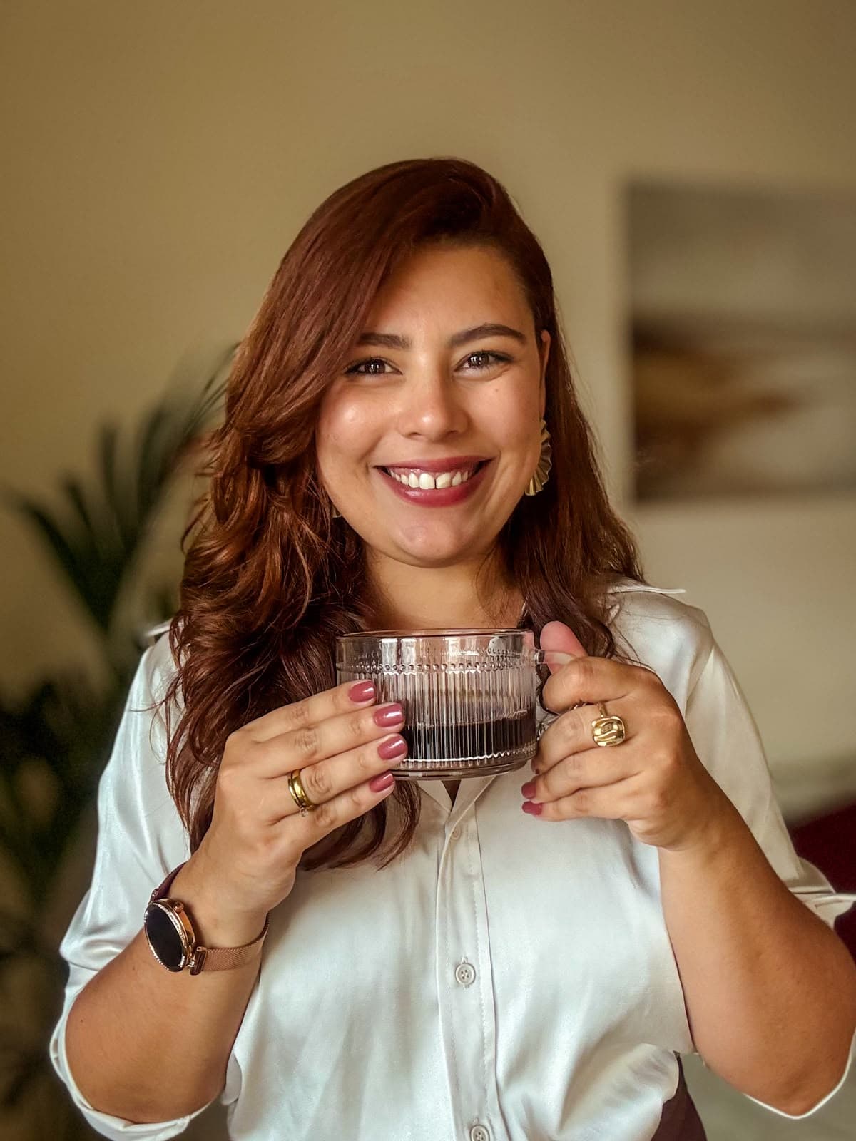 Taynara Oliveira sorrindo e segurando uma xícara